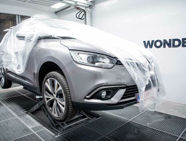 Flank van een grijze Renault onder een beschermende doek
